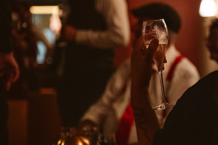 Guest in 1920s style raising a glass at a Ruby Lounge event