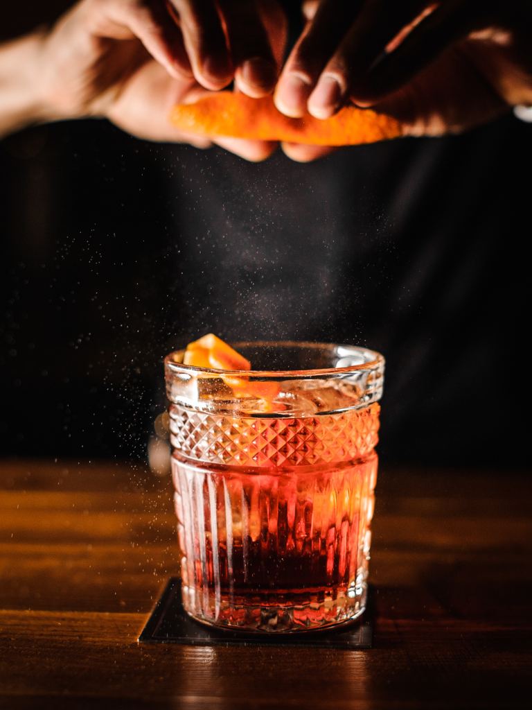 A signature cocktail being finished with an orange twist at The Ruby Lounge